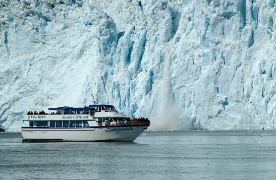 A boat moves past a large glacier