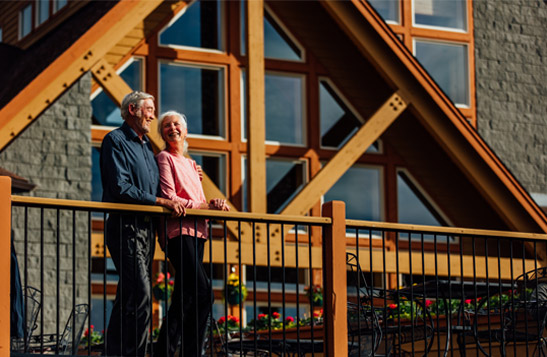 A couple standing on the balcony outside of the Talkeetna Alaskan Lodge