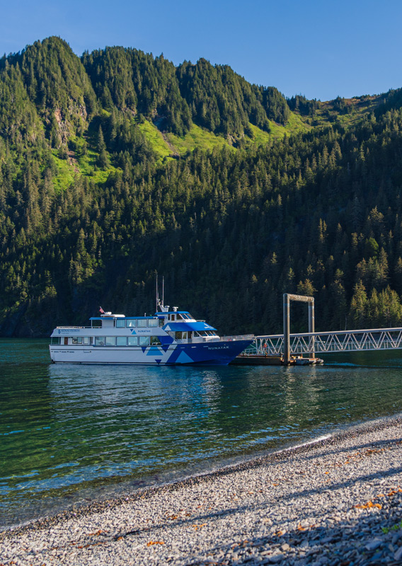 A Kenai Fjords Tours boat docked at Fox Island