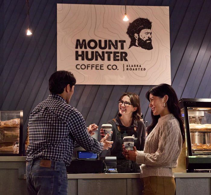 Two customers receiving coffee from Mount Hunter Coffee Co. barista
