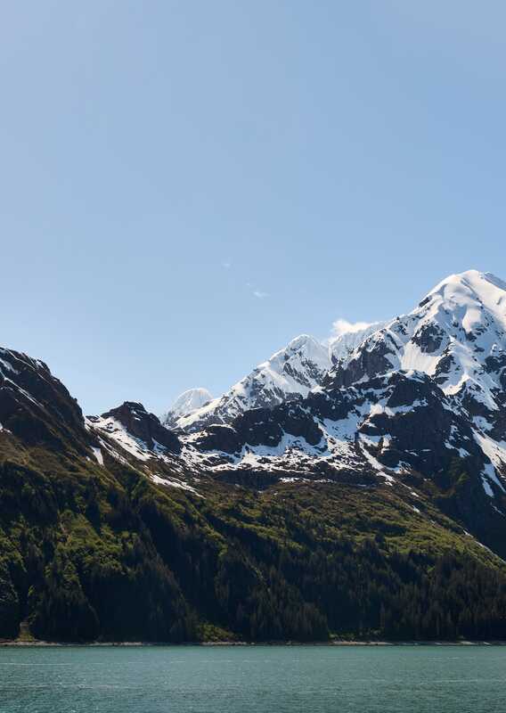 A landscape view across the sea towards mountains.