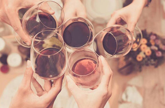 Top view of hands toasting glasses of wine.