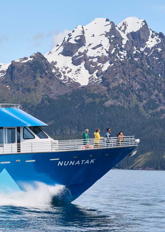 A group of people at the prow of a sightseeing boat.