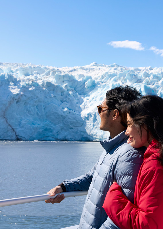 A couple looking at the glacier view from a Kenai Fjords Tour boat